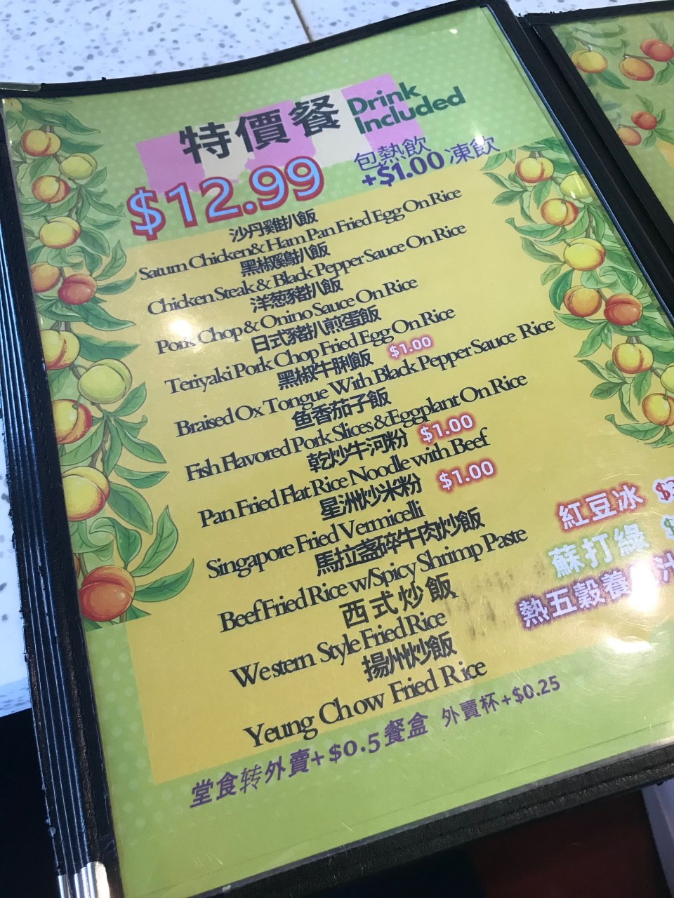 chinese and english food menu decorated with peaches. there is kinds of fried rice, rice with cutlet, stir fried noodles, and all come with a drink for 12.99. there are extra surcharges listed around the menu.